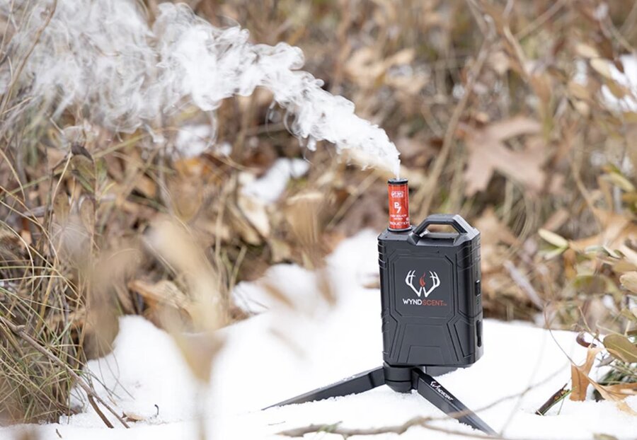 WyndScent scent vaporizer releasing a cloud of scent in the snowy woods